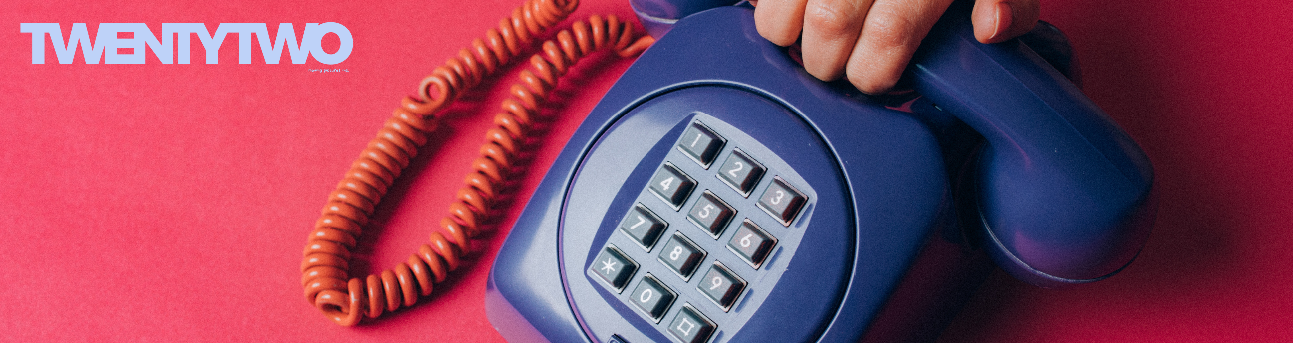 TwentyTwo beside a hand holding a blue telephone handset