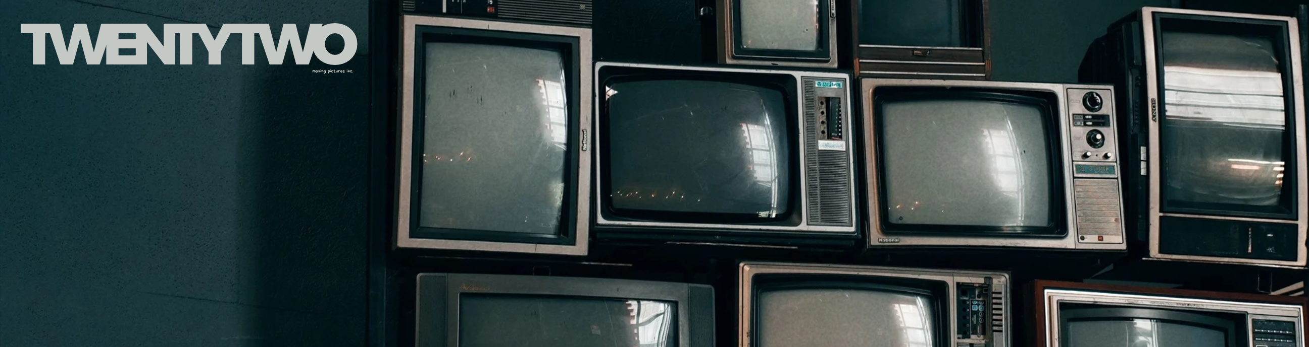 TwentyTwo beside a wall of vintage television sets